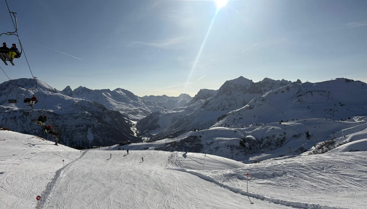 Schneebedeckte Berglandschaft mit Skifahrern auf der Piste und Sessellift unter strahlendem Himmel | © DAV-FN / V. u. S. Schmidhuber