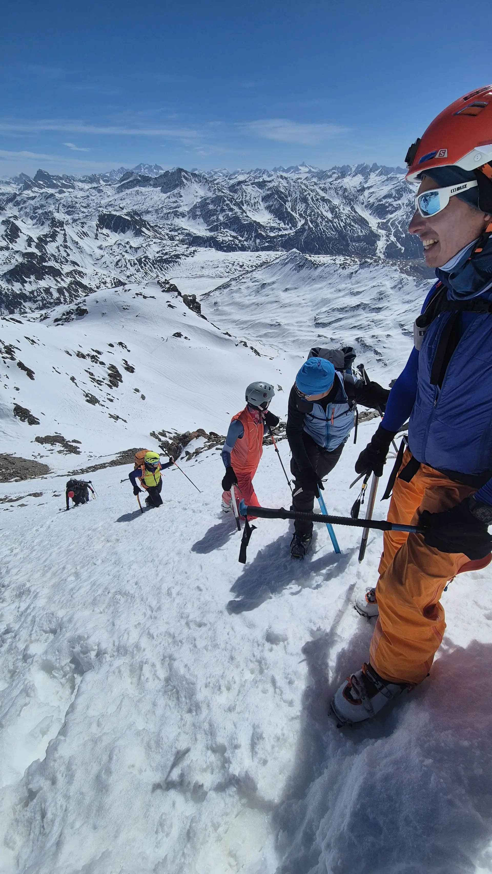 Gruppe von Bergsteigern mit Helmen und Ausrüstung steigt steilen schneebedeckten Hang in alpiner Berglandschaft hinauf | © DAV-FN / R. Lebedeff
