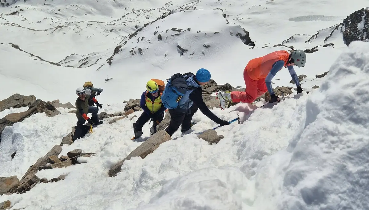 Gruppe von Bergsteigern mit Helmen und Rucksäcken klettert steilen schneebedeckten Hang hinauf | © DAV-FN / R. Lebedeff