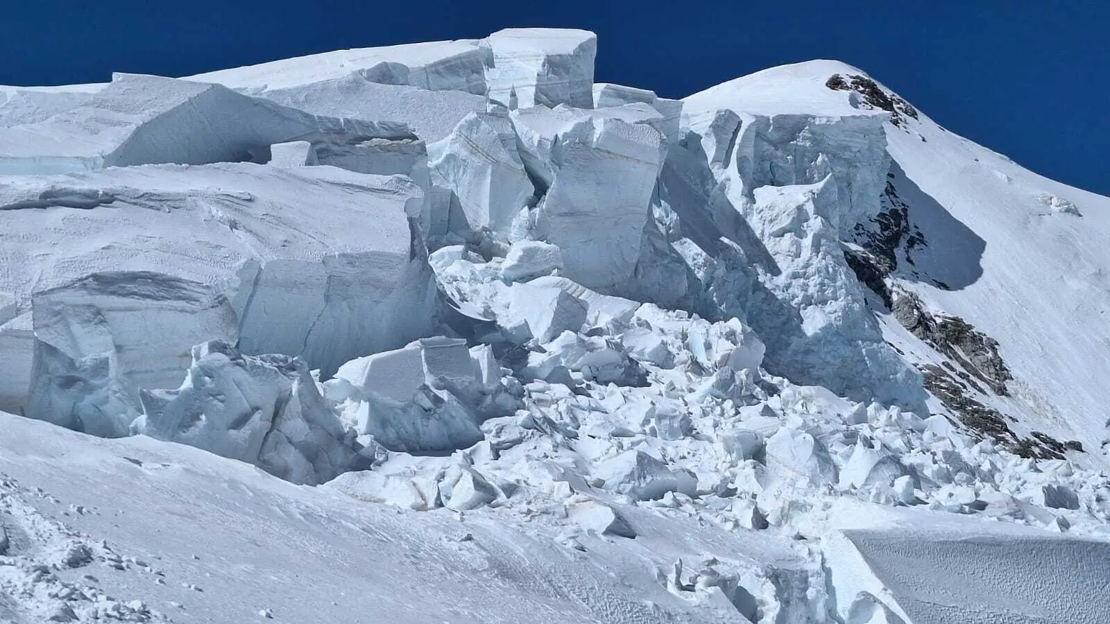 Schneebedeckter Berggipfel mit großen, zerklüftetem Gletscherbruch unter klarem blauem Himmel | © DAV-FN / R. Gersten