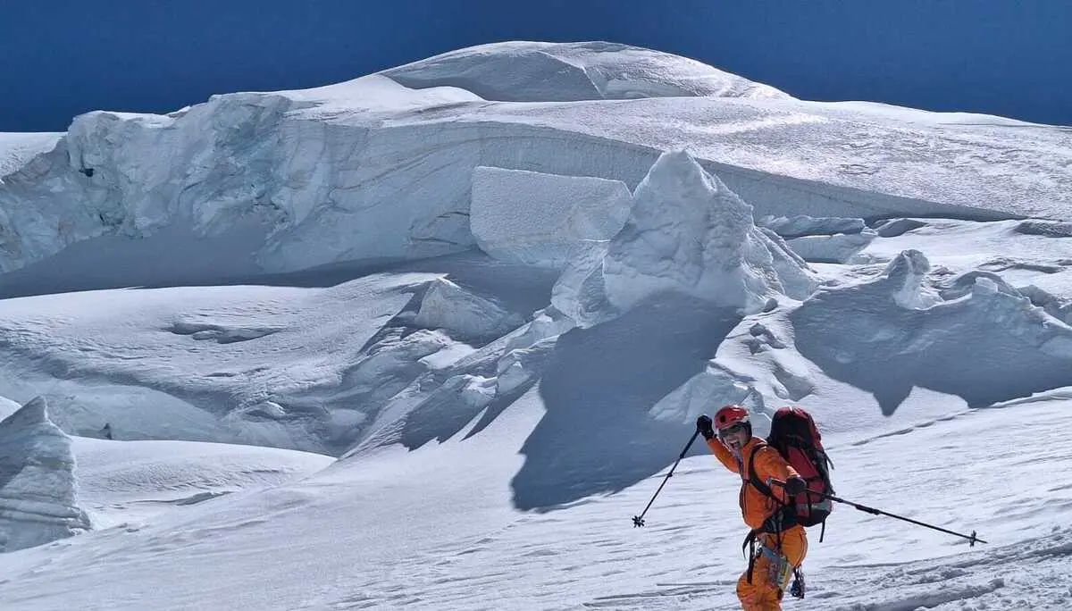 Bergsteiger mit rotem Rucksack und oranger Kleidung bei Abfahrt auf schneebedecktem Gletscher | © DAV-FN / R. Gersten