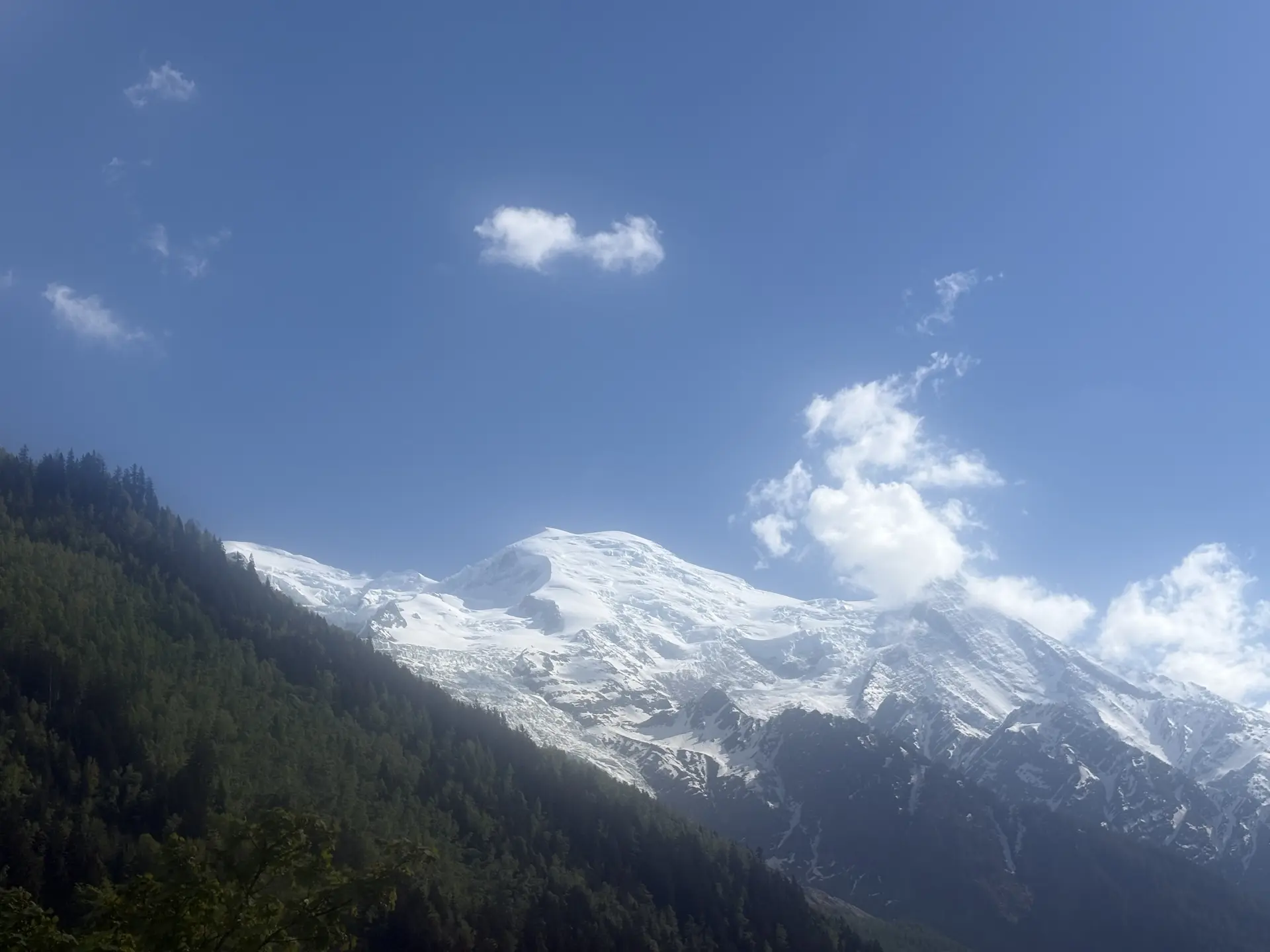 Schneebedeckte Berggipfel mit bewaldeten Hängen unter blauem Himmel mit einzelnen Wolken | © DAV-FN / R. Gersten