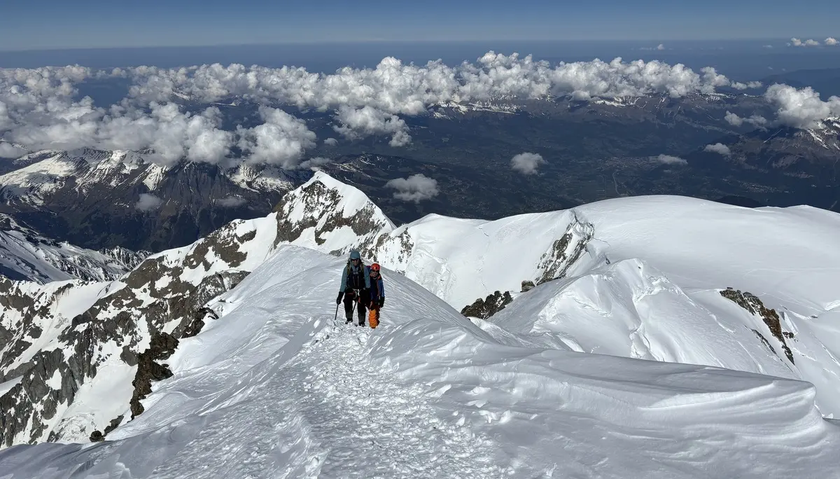 Zwei Personen wandern auf einem schneebedeckten Berggrat unter blauem Himmel mit Wolken und Bergpanorama im Hintergrund | © DAV-FN / R. Gersten