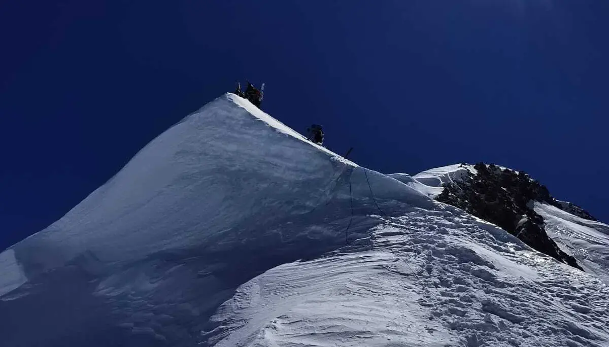 Bergsteiger auf schneebedecktem Grat unter strahlend blauem Himmel mit greller Sonne | © DAV-FN / R. Gersten