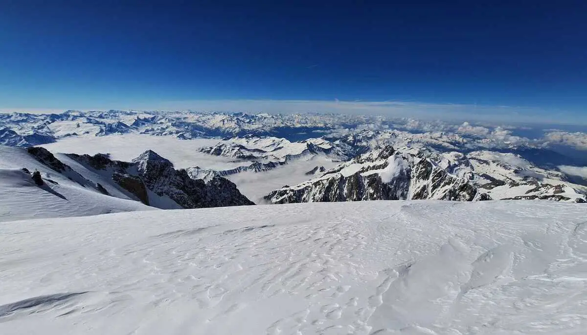 Weite Schneelandschaft mit Berggipfeln und wolkenbedecktem Himmel im Hintergrund | © DAV-FN / R. Gersten