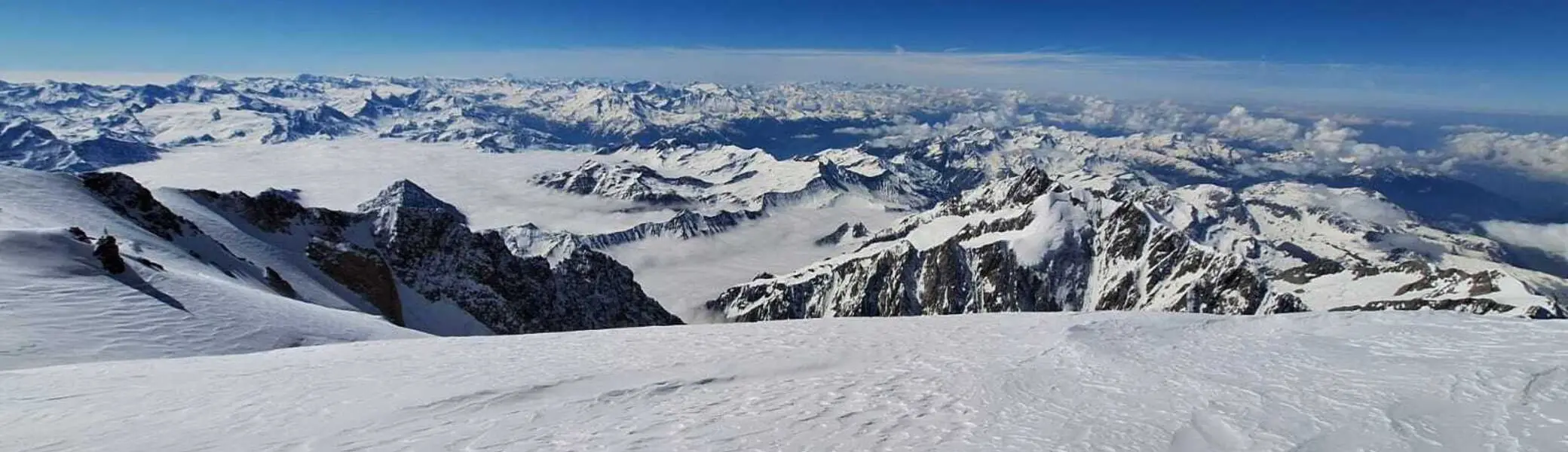 Weite Schneelandschaft mit Berggipfeln und wolkenbedecktem Himmel im Hintergrund | © DAV-FN / R. Gersten