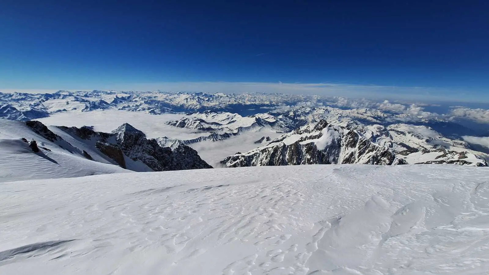 Weite Schneelandschaft mit Berggipfeln und wolkenbedecktem Himmel im Hintergrund | © DAV-FN / R. Gersten