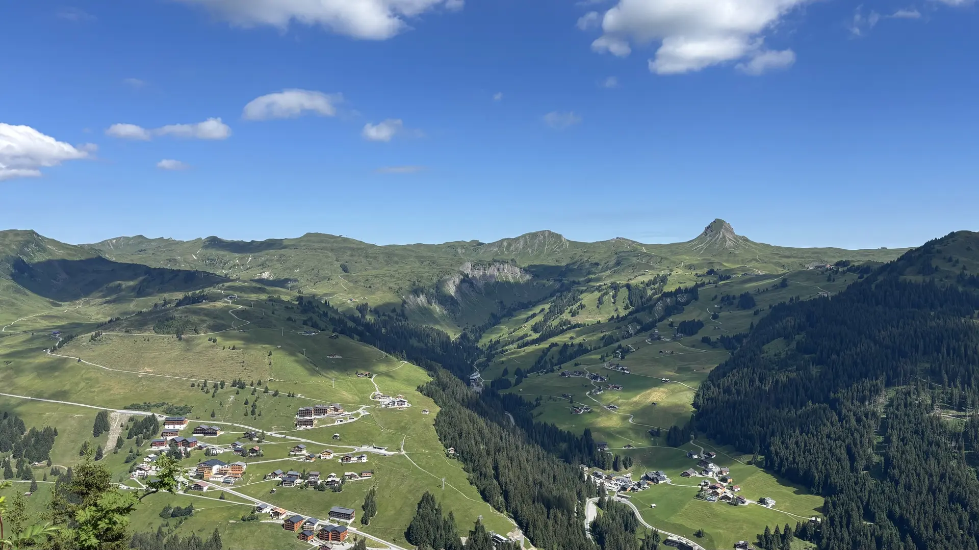 Berglandschaft mit grünen Wiesen, verstreuten Häusern und blauem Himmel mit wenigen Wolken | © DAV - FN / A. Schech