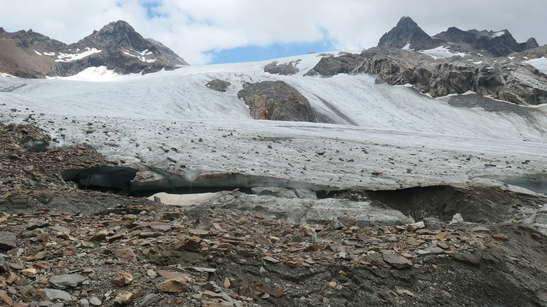 Gletscher mit sichtbarer Gletscherspalte vor felsigem Berggelände unter bewölktem Himmel | © DAV - FN / S. Dischler
