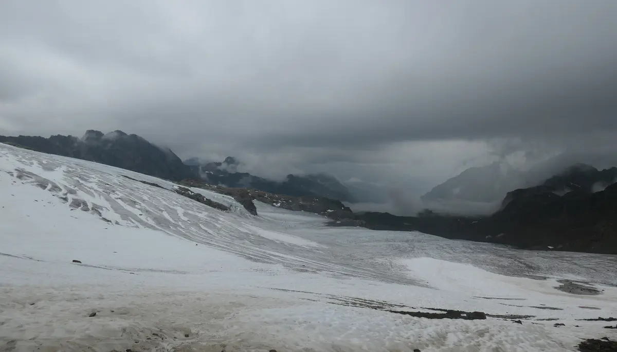 Schneebedeckte Berglandschaft unter bewölktem Himmel mit dunklen Berggipfeln im Hintergrund | © DAV - FN / S. Dischler