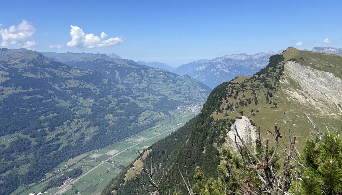 Berglandschaft mit bewaldeten Hängen, steilen Felswänden und einem Tal im Hintergrund unter blauem Himmel | © DAV - FN / A. Schech