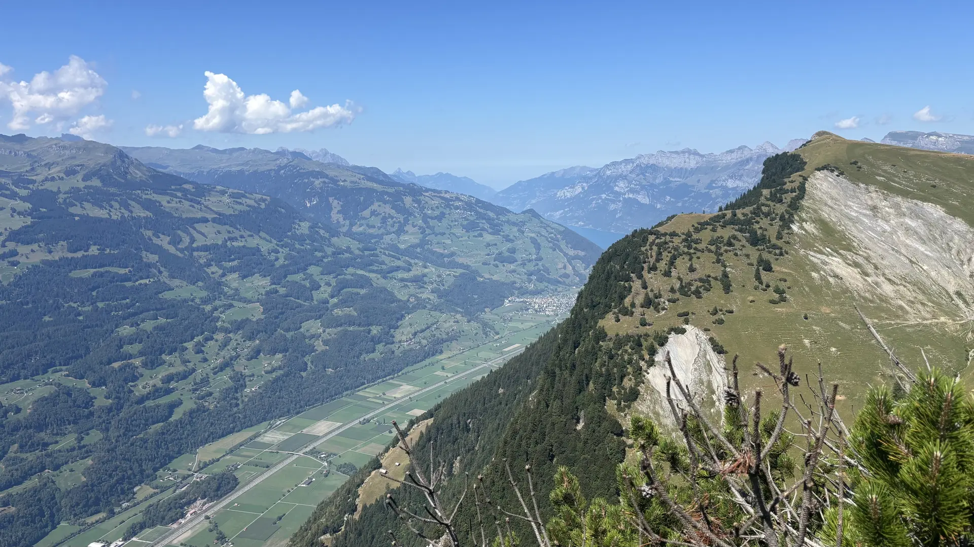 Berglandschaft mit bewaldeten Hängen, steilen Felswänden und einem Tal im Hintergrund unter blauem Himmel | © DAV - FN / A. Schech