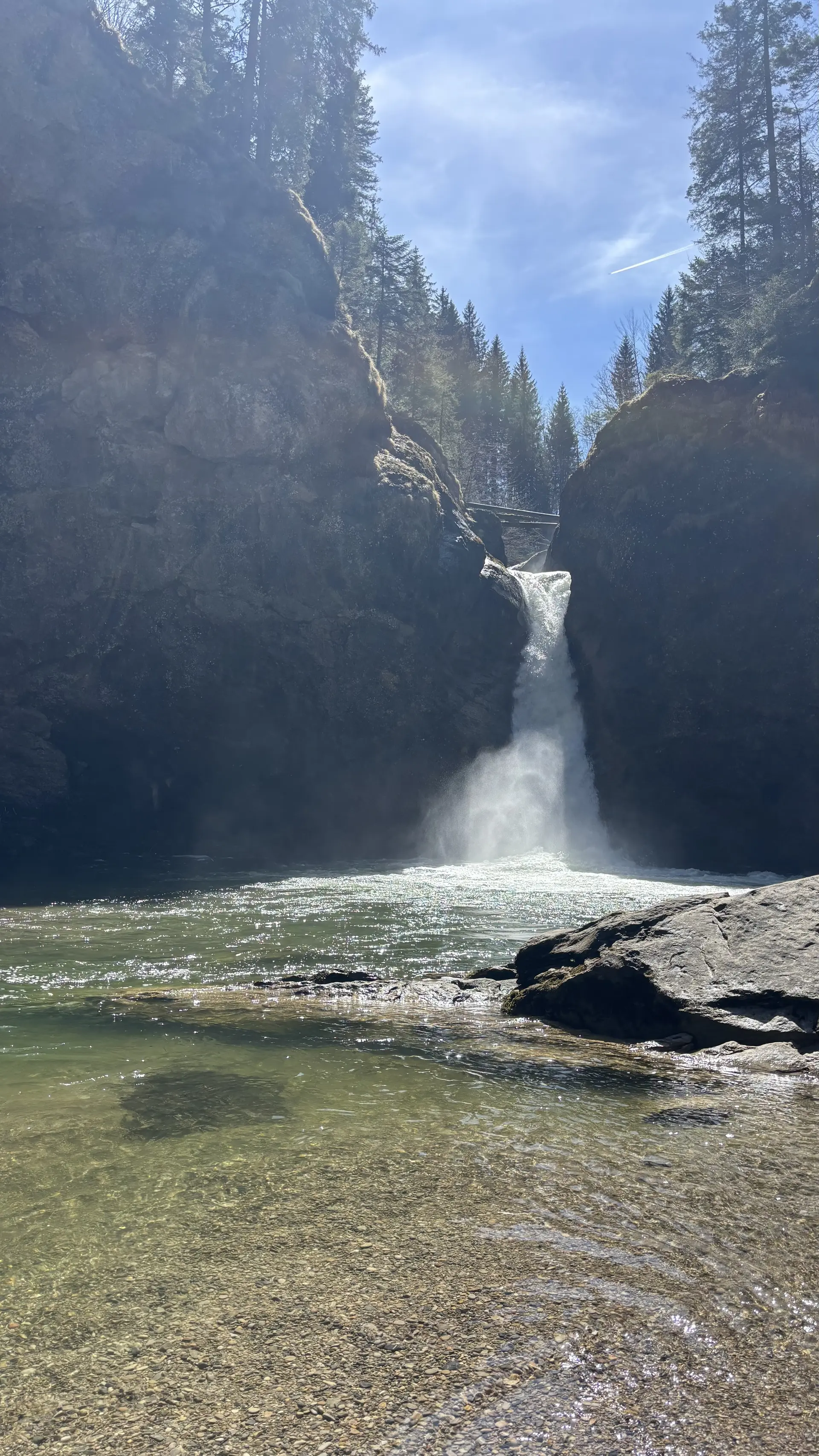 Wasserfall zwischen hohen Felsen mit Brücke darüber und klarem Wasser im Vordergrund | © DAV-FN / A. Schech