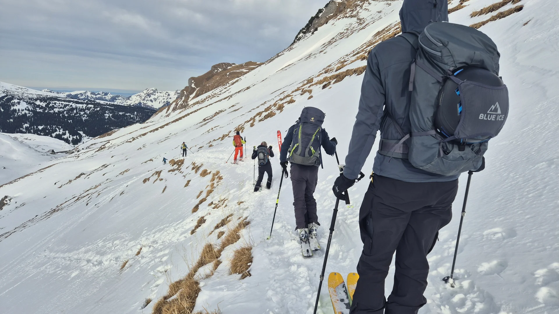 Gruppe von Skitourengehern mit Rucksäcken und Skistöcken auf schneebedecktem Bergpfad | © DAV-Fn / R. Lebedeff