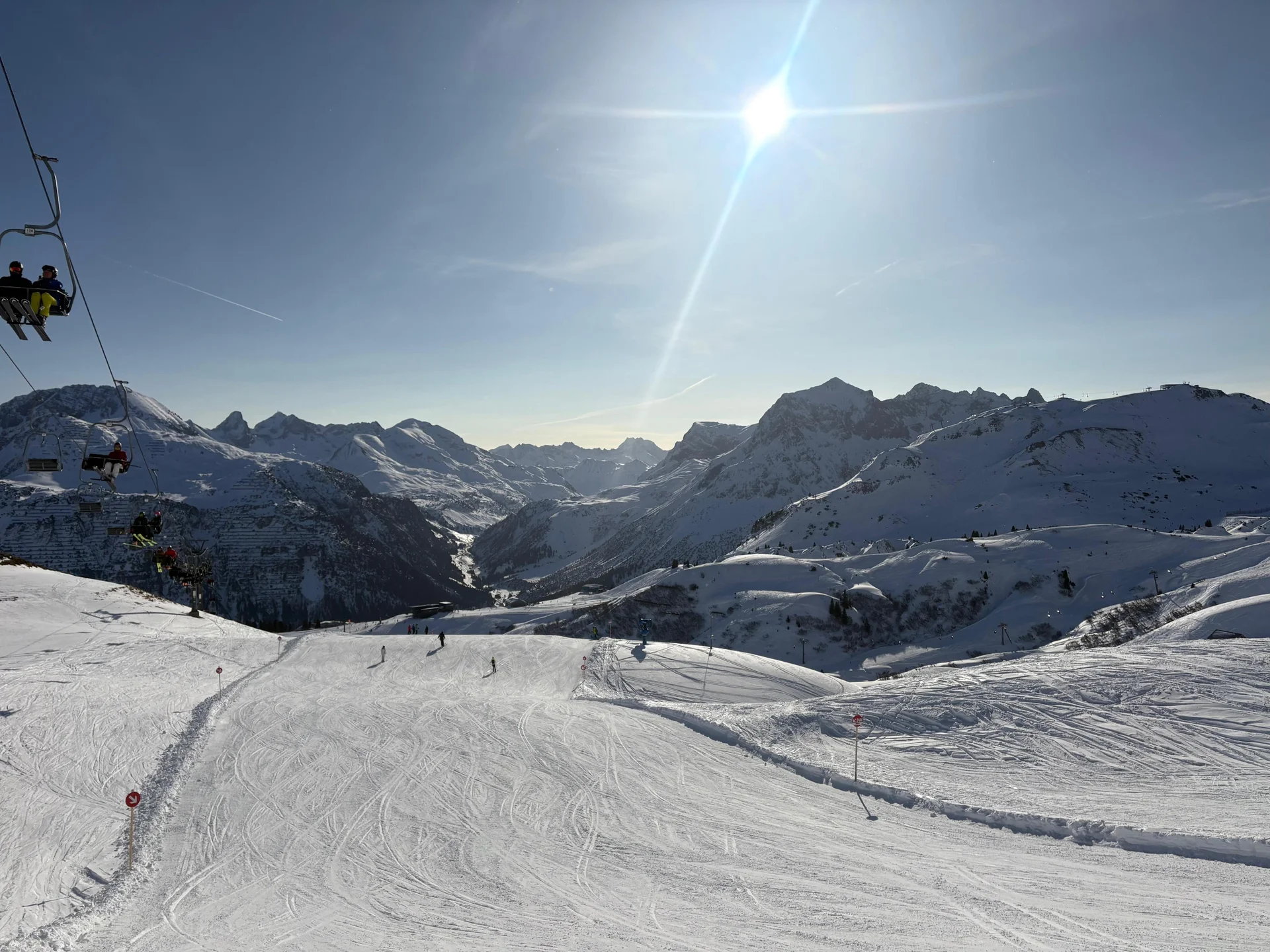 Schneebedeckte Berglandschaft mit Skifahrern auf der Piste und Sessellift unter strahlendem Himmel | © DAV-FN / V. u. S. Schmidhuber