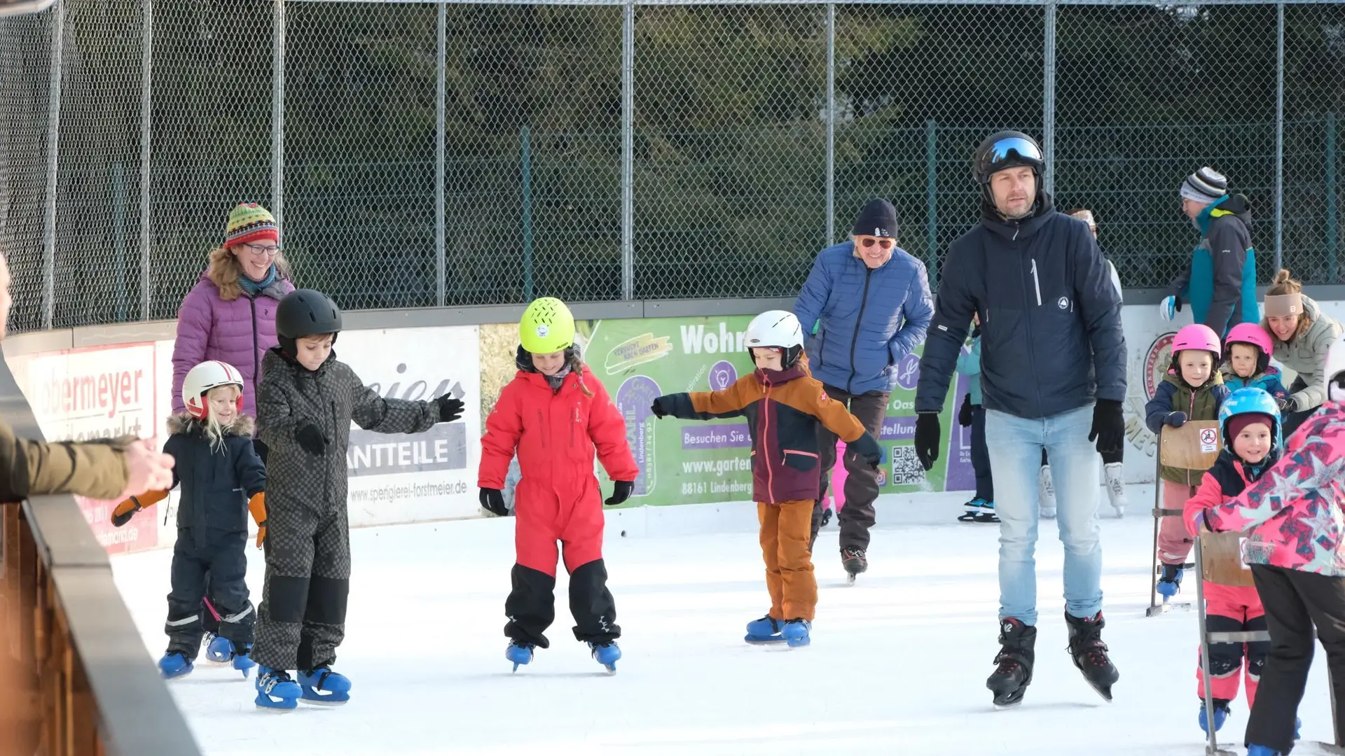 Mehrere Kinder und Erwachsene beim Schlittschuhlaufen auf einer Eisbahn im Freien | © DAV-FN / A. Schababerle