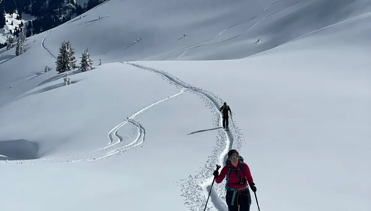 Zwei Skitourengeher wandern auf einer Spur durch verschneite Berge unter blauem Himmel | © DAV-FN / C. + C. Ritter