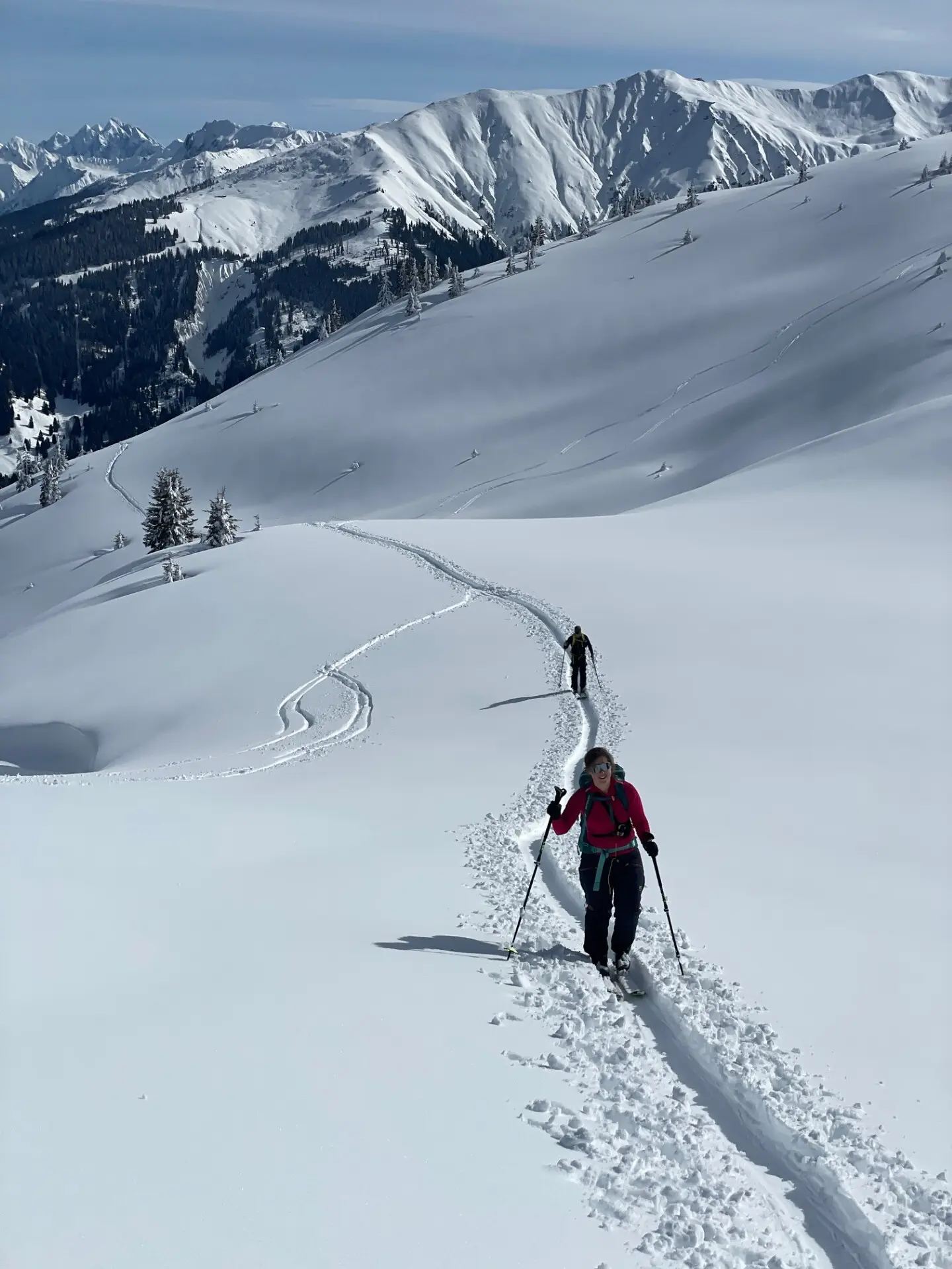 Zwei Skitourengeher wandern auf einer Spur durch verschneite Berge unter blauem Himmel | © DAV-FN / C. + C. Ritter