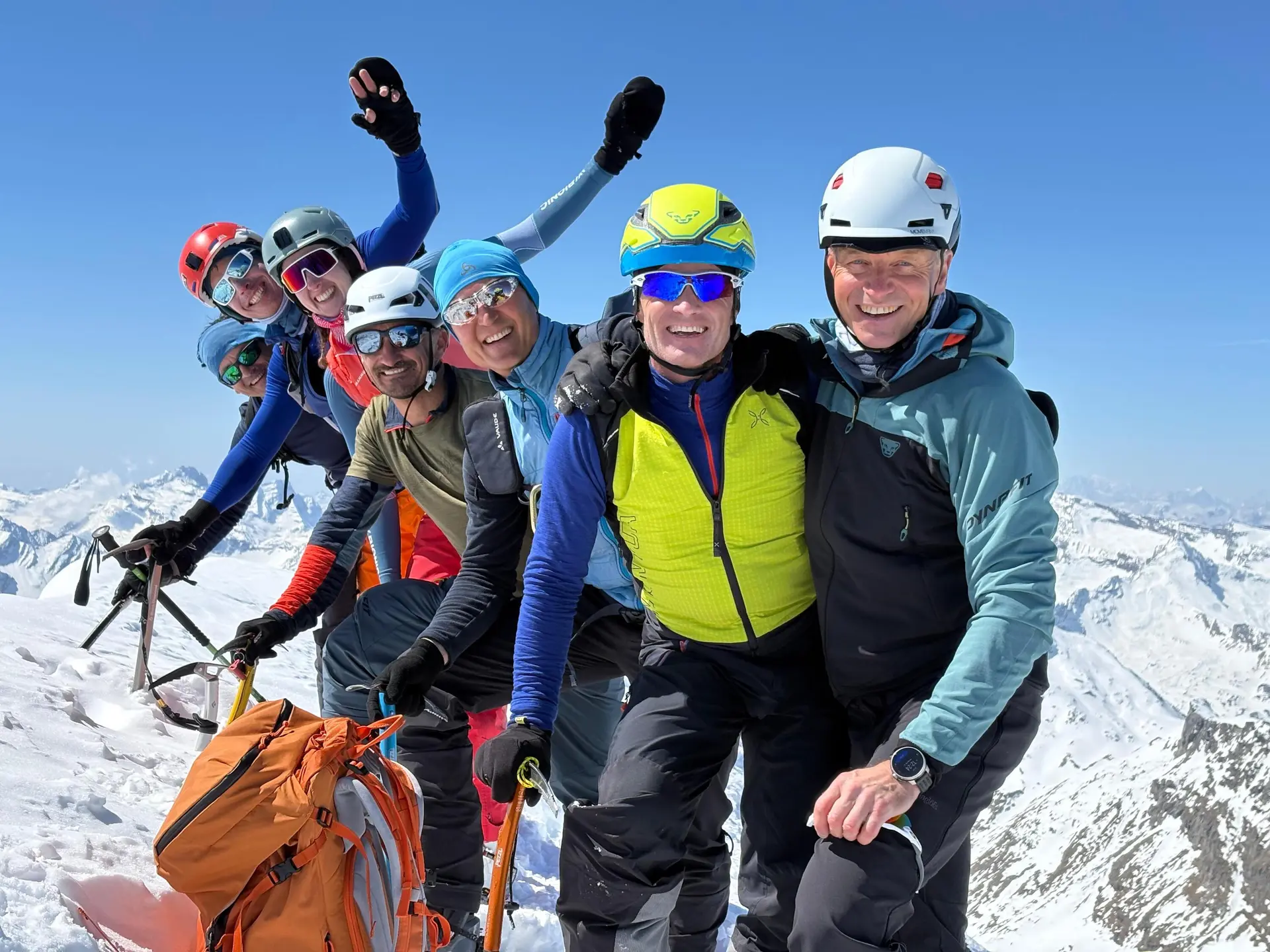 Gruppe von Bergsteigern mit Helmen und Kletterausrüstung auf schneebedecktem Gipfel mit Bergpanorama | © DAV-FN / R. Gersten