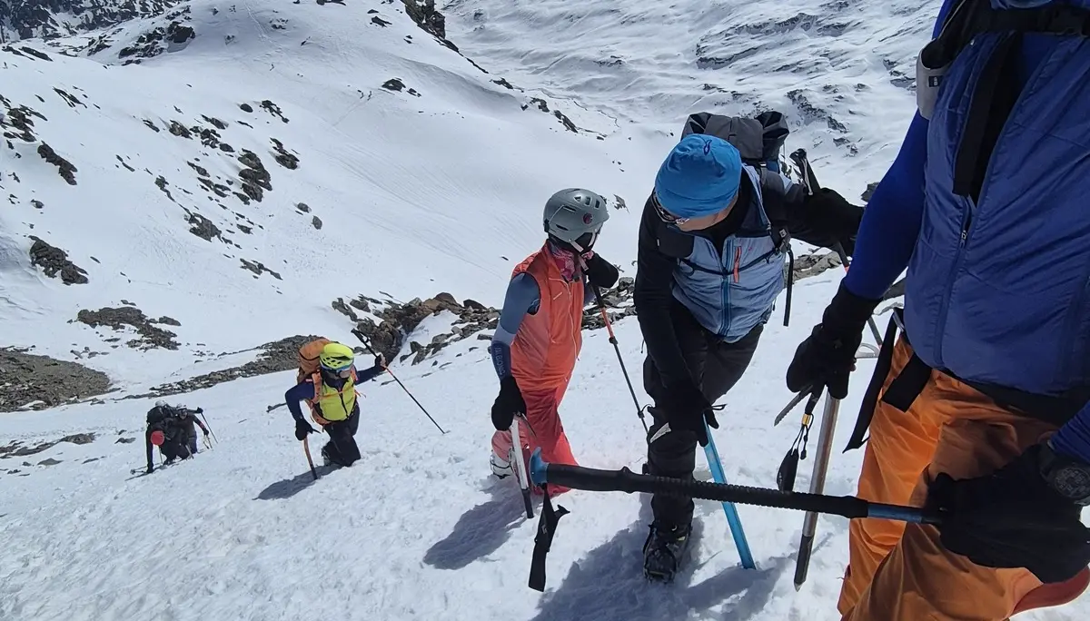 Gruppe von Bergsteigern mit Helmen und Ausrüstung steigt steilen schneebedeckten Hang in alpiner Berglandschaft hinauf | © DAV-FN / R. Lebedeff