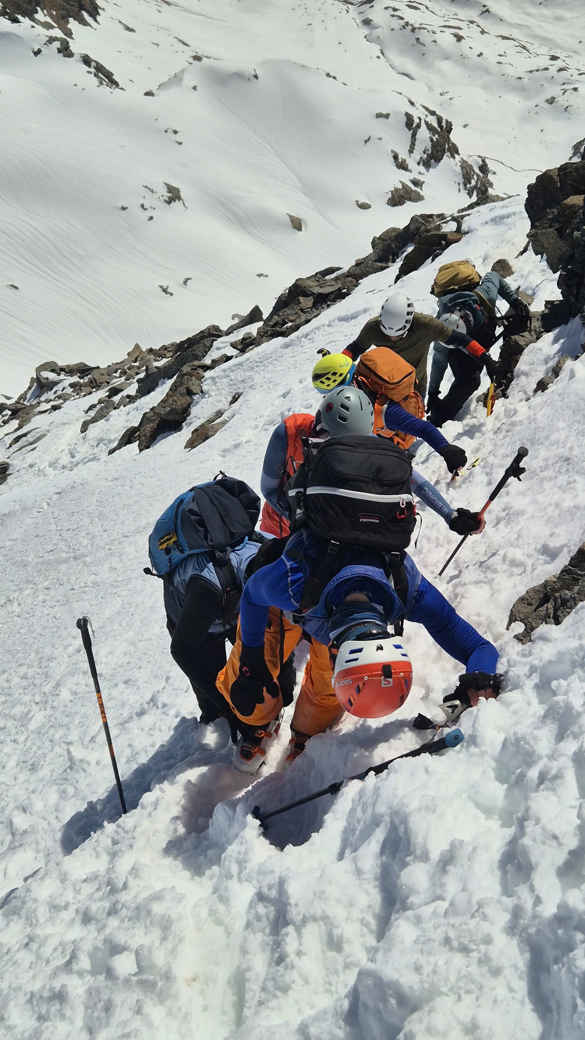 Gruppe von Bergsteigern mit Helmen und Rucksäcken klettert in steilem, schneebedecktem Gelände | © DAV-FN / R. Lebedeff