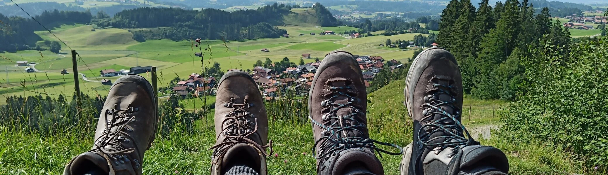 Zwei paar Füsse mit Bergstiefel mit weiter Sicht in ein Allgäuer Tal  | © DAV-FN