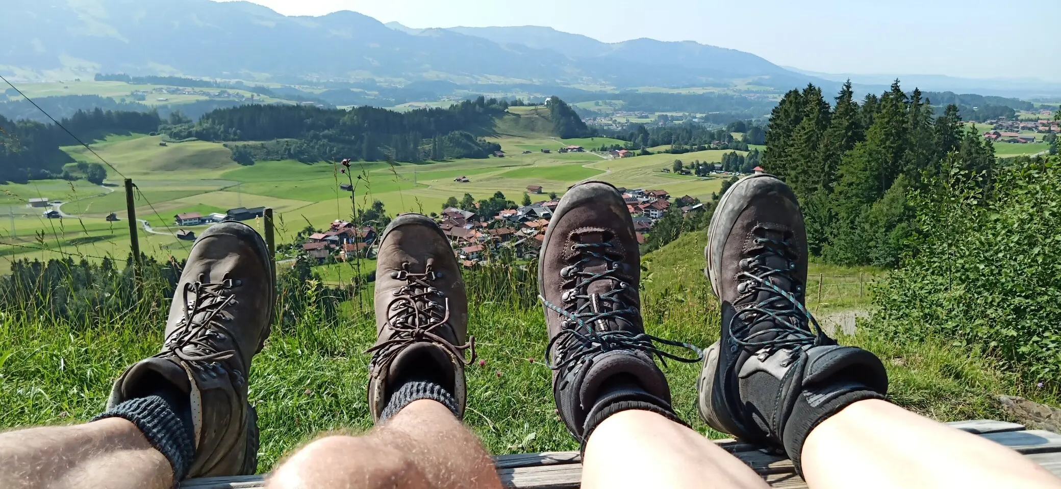 Zwei paar Füsse mit Bergstiefel mit weiter Sicht in ein Allgäuer Tal  | © DAV-FN
