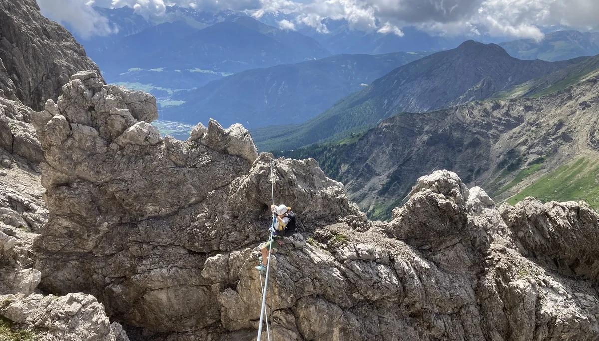 Eine Kletterin auf einer Seilbrücke des Imster Klettersteigs | © DAV-FN /  A. Martin