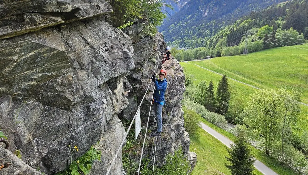 Zwei Personen klettern an einer Felswand mit Sicherungsseilen in einer grünen Berglandschaft | © DAV-FN / S. Meyer