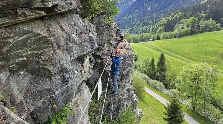Zwei Personen klettern an einer Felswand mit Sicherungsseilen in einer grünen Berglandschaft | © DAV-FN / S. Meyer