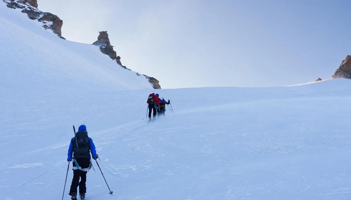 Einige Skitourengeher steigen auf schneebedecktem Hang unter klarem Himmel bergauf. | © DAV-FN / R. Gersten u. L. Chr. Fischer