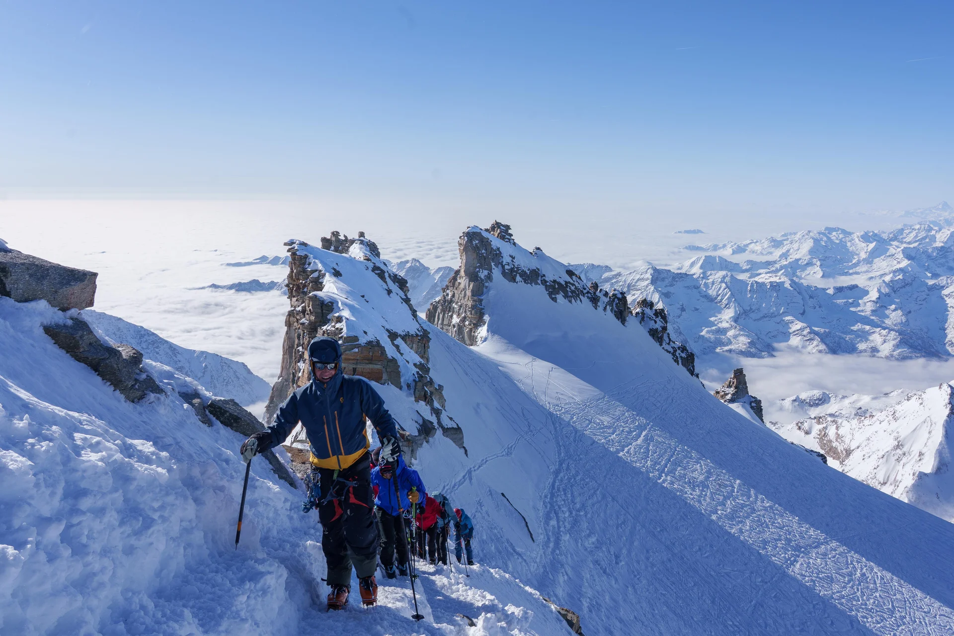 Bergsteiger in Ausrüstung mit Steigeisen und Eispickeln auf schneebedecktem Grat in den Alpen bei klarem Himmel | © DAV-FN / R. Gersten u. L. Chr. Fischer