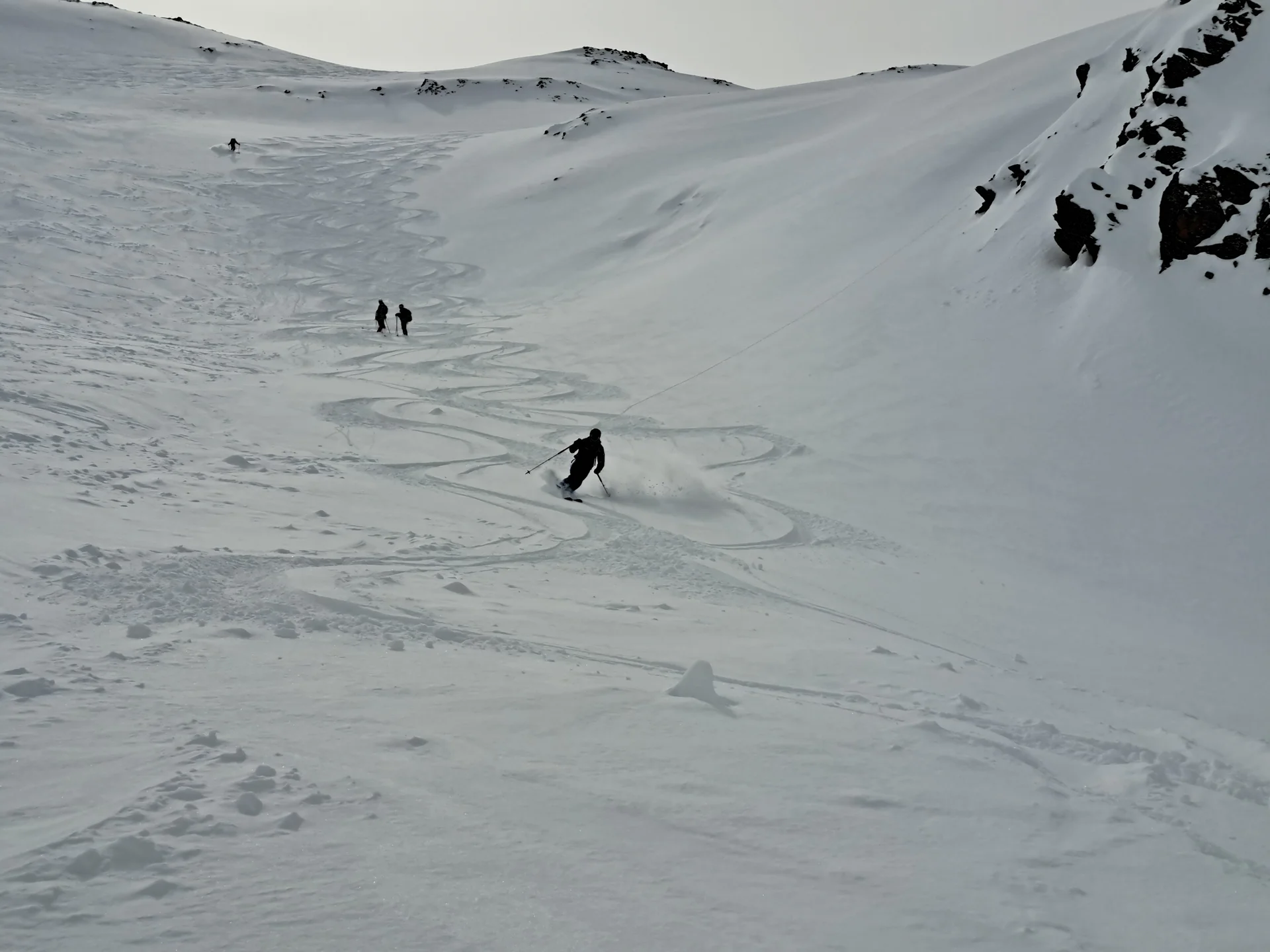 Skifahrer fährt eine verschneite Bergabfahrt an der Tiergartenspitze, zwei weitere stehen im Hintergrund | © DAV-FN / R.Lebedeff, D. Lexen