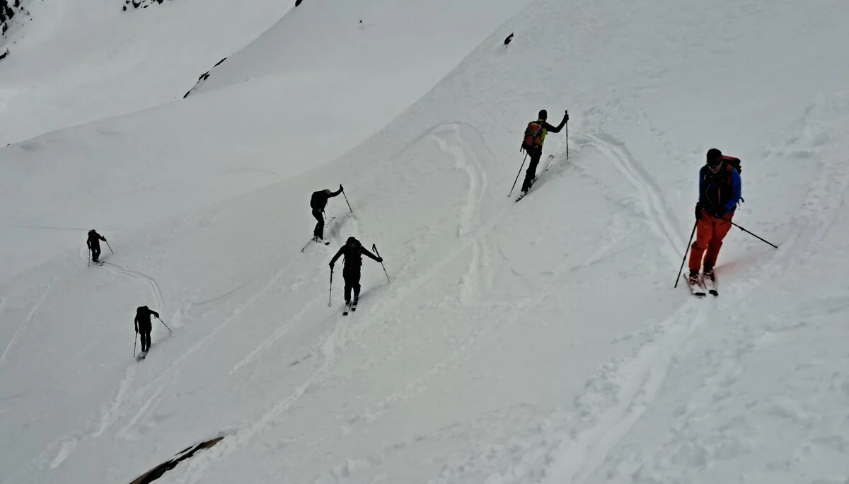Sechs Skifahrer steigen mit Skistöcken einen steilen, schneebedeckten Hang hinauf | © DAV-FN / R.Lebedeff, D. Lexen