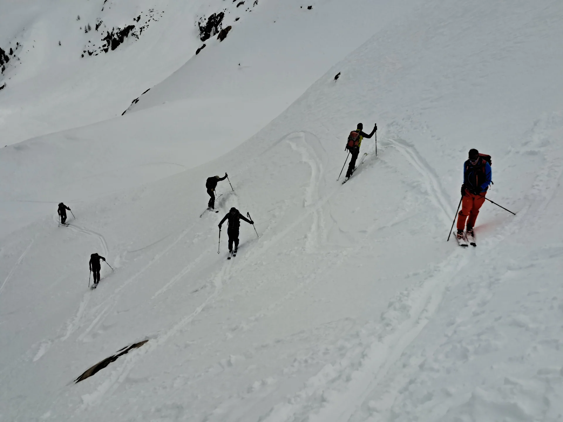 Sechs Skifahrer steigen mit Skistöcken einen steilen, schneebedeckten Hang hinauf | © DAV-FN / R.Lebedeff, D. Lexen