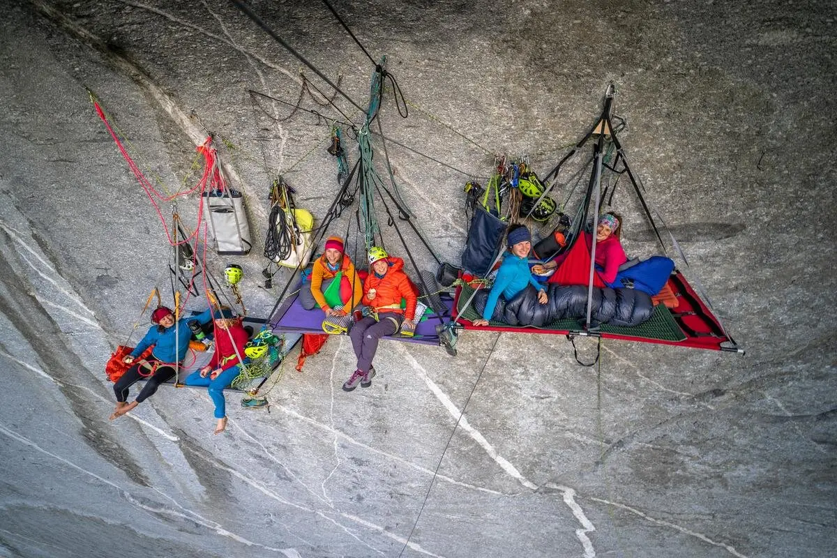 Gruppe von Bergsteigern sitzt auf zwei Portaledge an einer BigWall mit Kletterausrüstung | © Copyright DAV, Aufnahme Silvan Metz