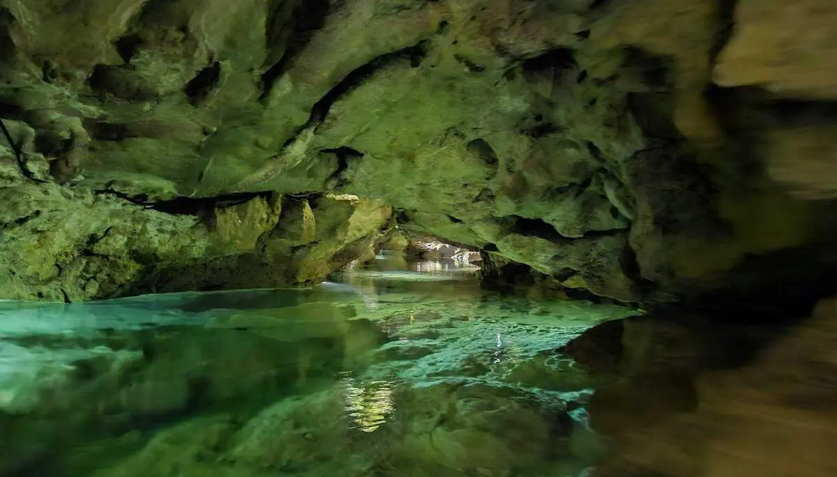 Unterirdischer Fluss in einer mit Moos bewachsenen Höhle mit Felsformationen | © DAV-FN / M. Gross