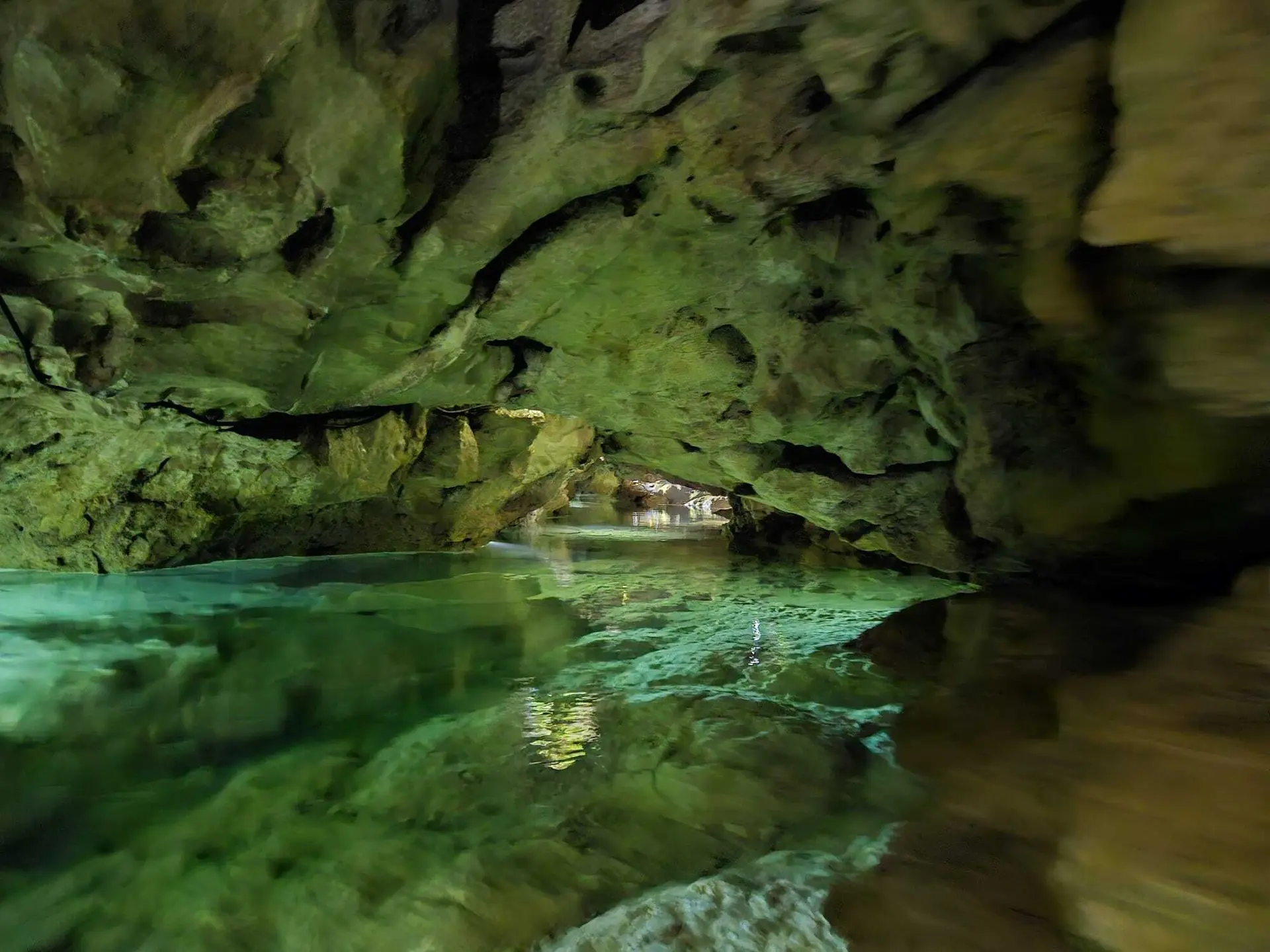 Unterirdischer Fluss in einer mit Moos bewachsenen Höhle mit Felsformationen | © DAV-FN / M. Gross
