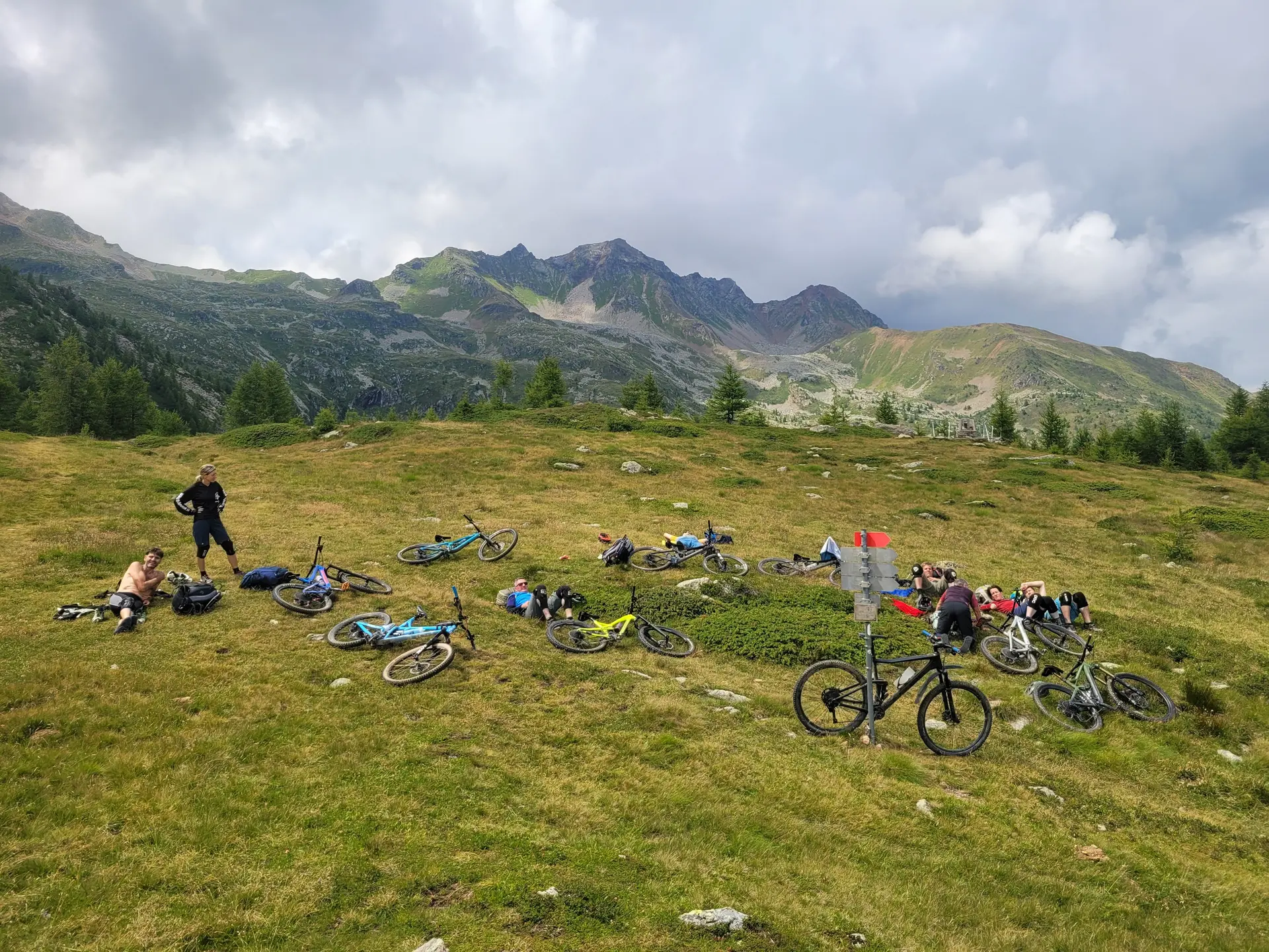 Gruppe von Menschen mit Mountainbikes auf einer Wiese vor bewaldeten Bergen unter bewölktem Himmel | © DAV-FN / E. Flöth, M. Arzner, S. Haberer 