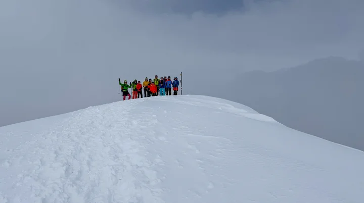 Gruppe von Skitourengehern auf einem verschneiten Hügel vor heranziehenden Wolken | © DAV-FN / Rucksack