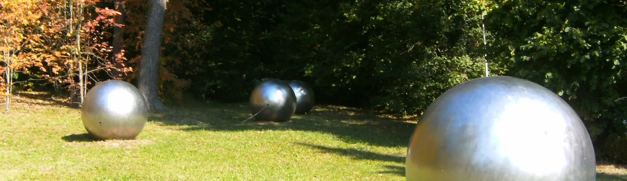 Drei große glänzende Metallkugeln auf einer Wiese vor Bäumen | © Von Roland.h.bueb - Eigenes Werk, CC BY 3.0, https://commons.wikimedia.org/w/index.php?curid=44358422