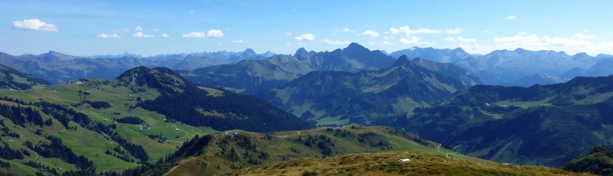 Berglandschaft mit grasbewachsenen Hügeln, kleinen Wasserflächen und dahinter mehreren Bergketten unter blauem Himmel mit wenigen Wolken | © Von Reinhard Müller - Eigenes Werk, CC BY-SA 4.0, httpscommons.wikimedia.orgwindex.phpcurid=43196985