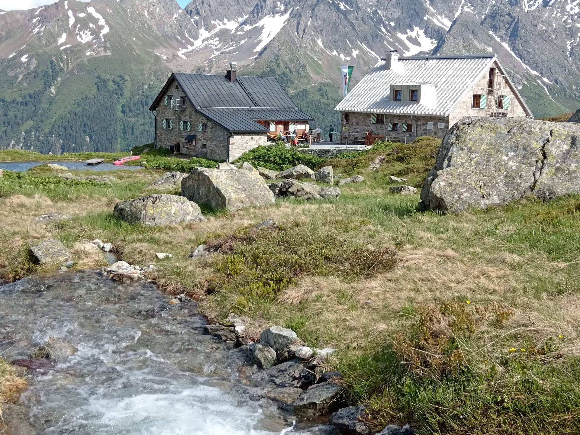 Blick über Bach hinweg zur Friedrichshafener Hütte und den See | © DAV-FN / J. Otten
