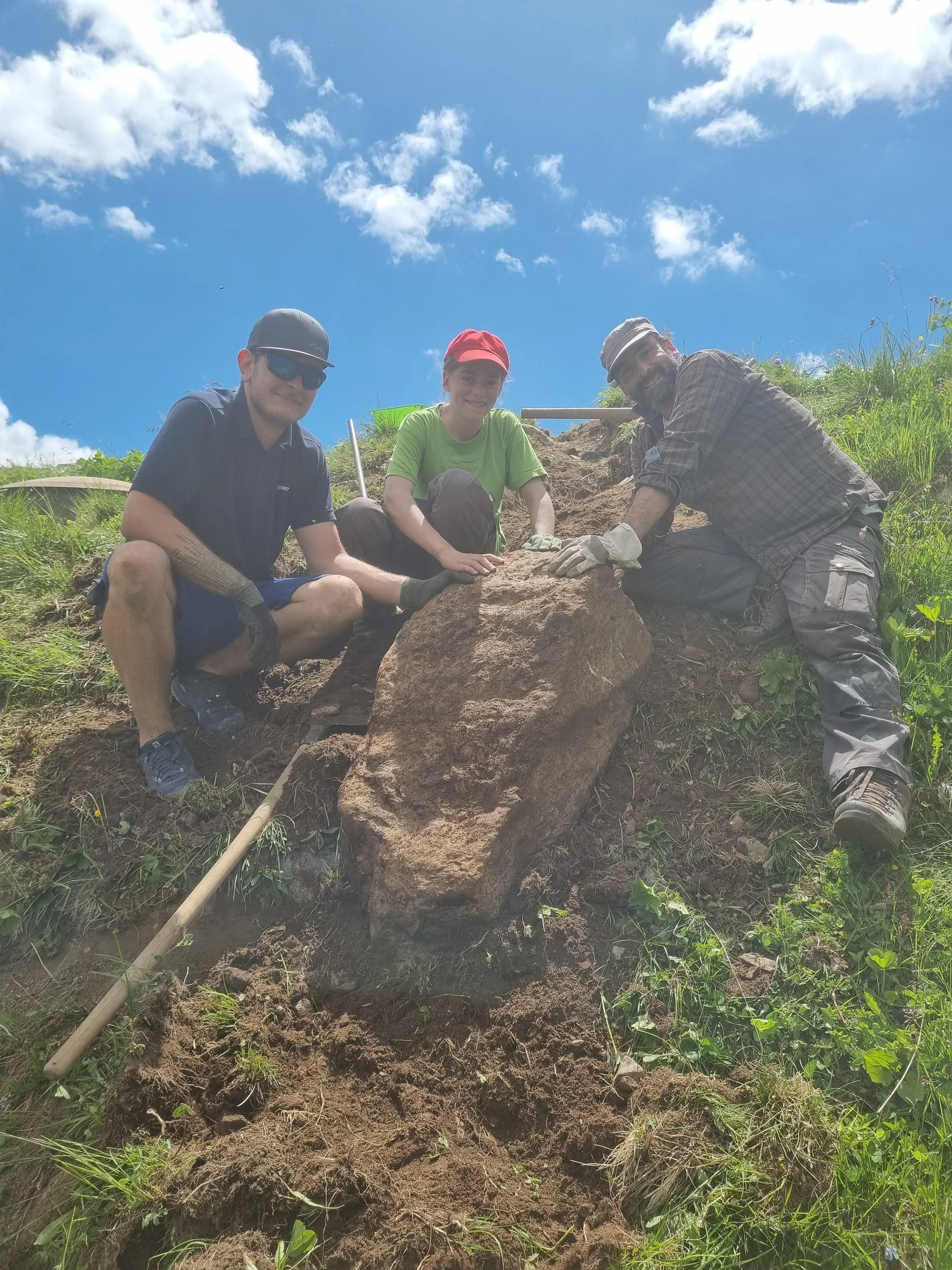 Drei Personen graben an einem Hang und heben einen großen Stein aus der Erde | © DAV-FN / R. Klees o. R. Zahner