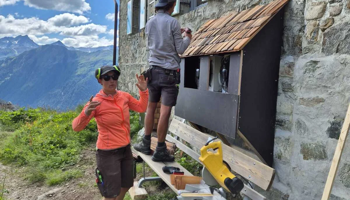 Zwei Personen arbeiten an der Holzverkleidung mit Schindeldach an der Häfler Hütte bei sonnigem Wetter | © DAV-FN / R. Klees o. R. Zahner