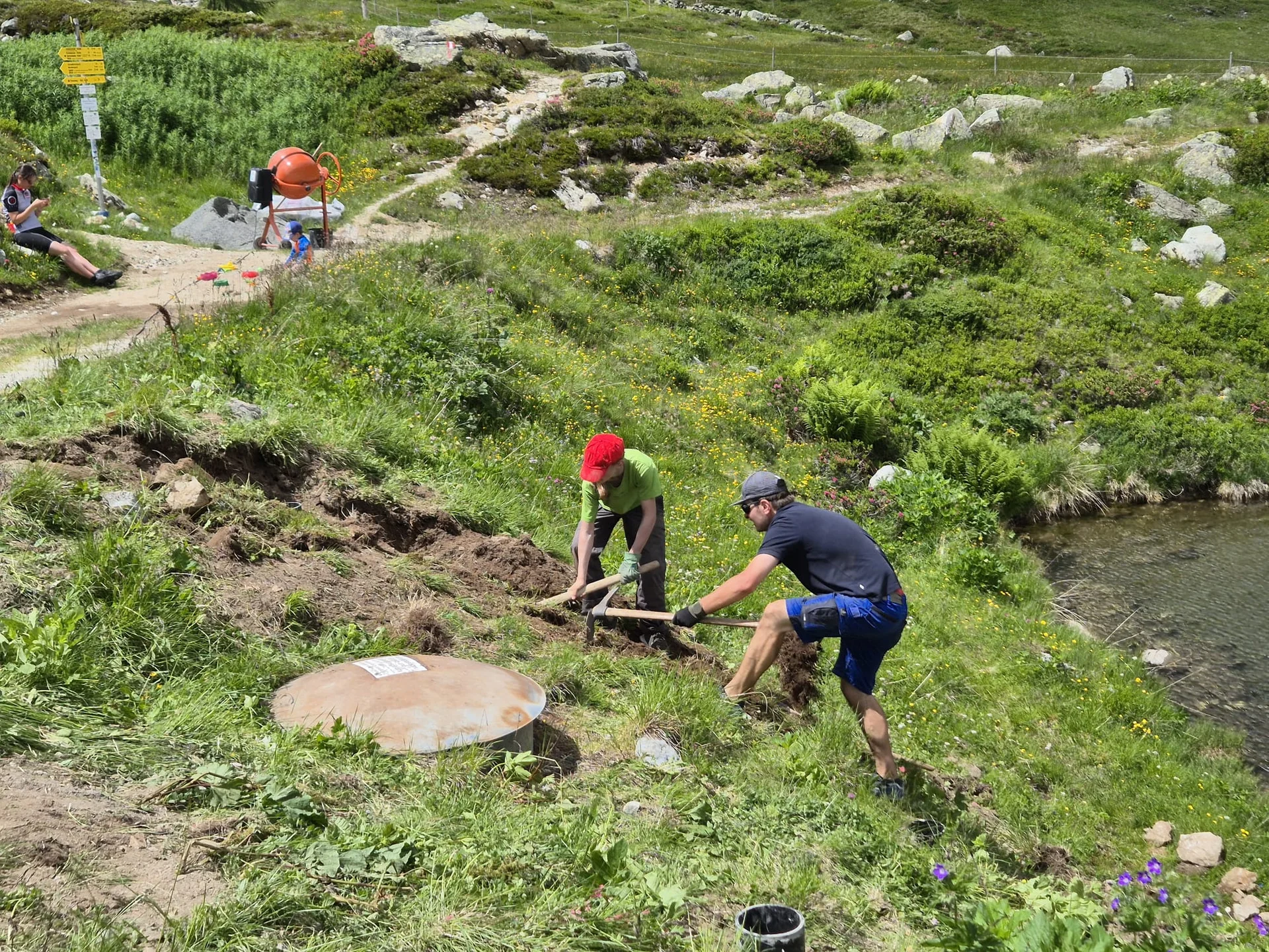 Zwei Jungen graben mit Schaufeln in einer grünen Wiesenlandschaft neben einem kleinen Gewässer | © DAV-FN / R. Klees o. R. Zahner