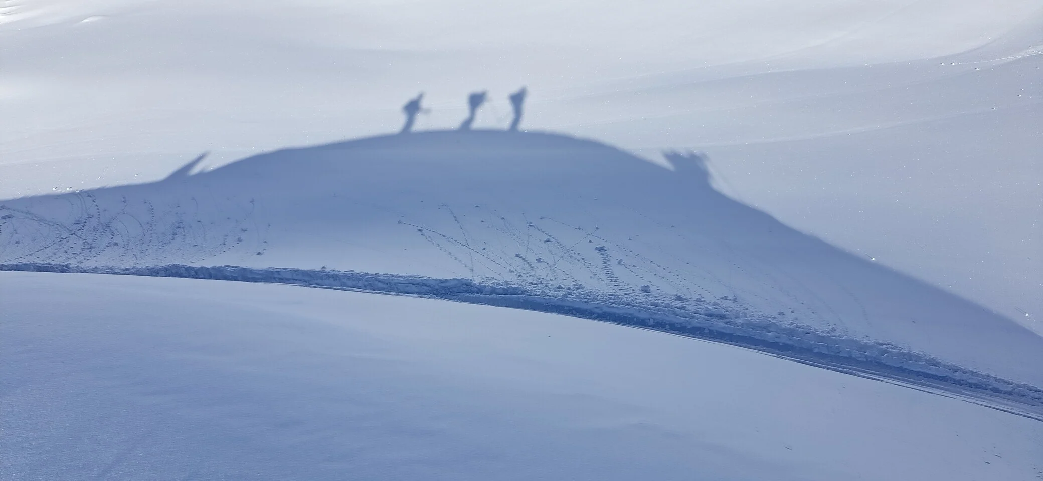 Blick auf das Schattenbild von Bergsportler*innen im Schnee | © 2023 - DAV Friedrichshafen